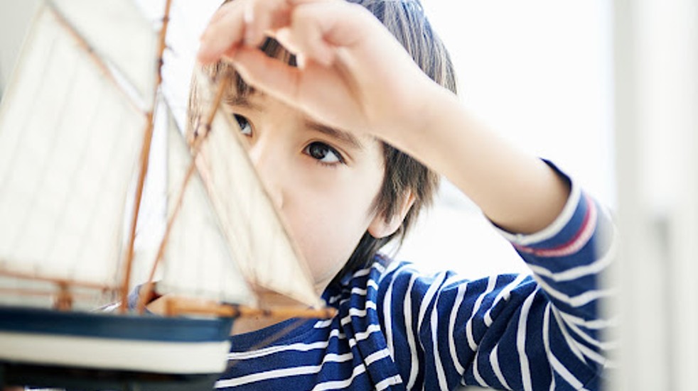 Child holding model boat